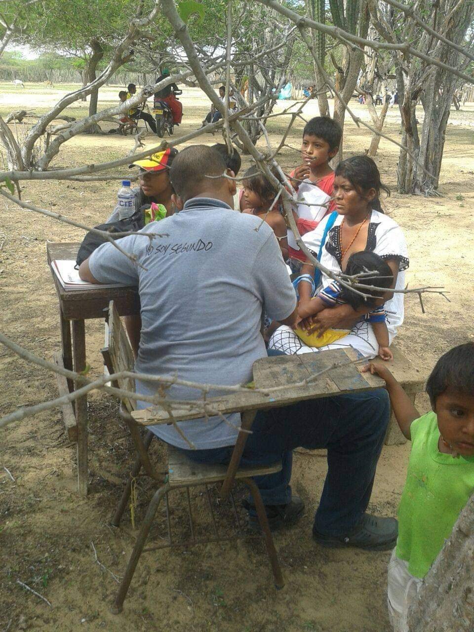 Voluntaria de la fundación atendiendo a una mujer wayúu durante una jornada