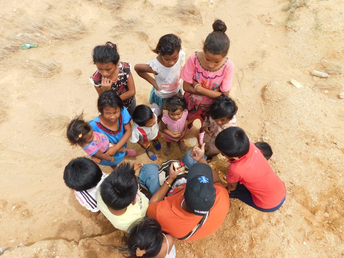 Grupo de niños reunidos en círculo alrededor de una actividad de enseñanza