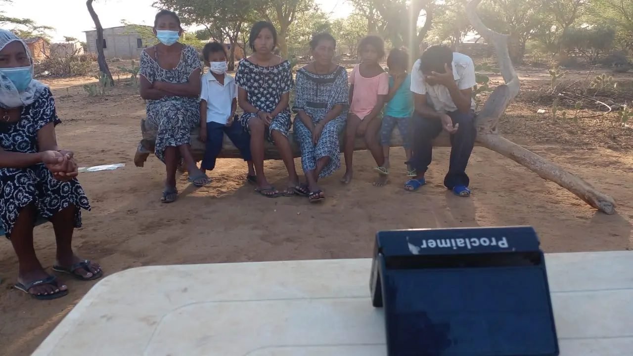Grupo reunido en círculo escuchando la lectura de un pasaje bíblico