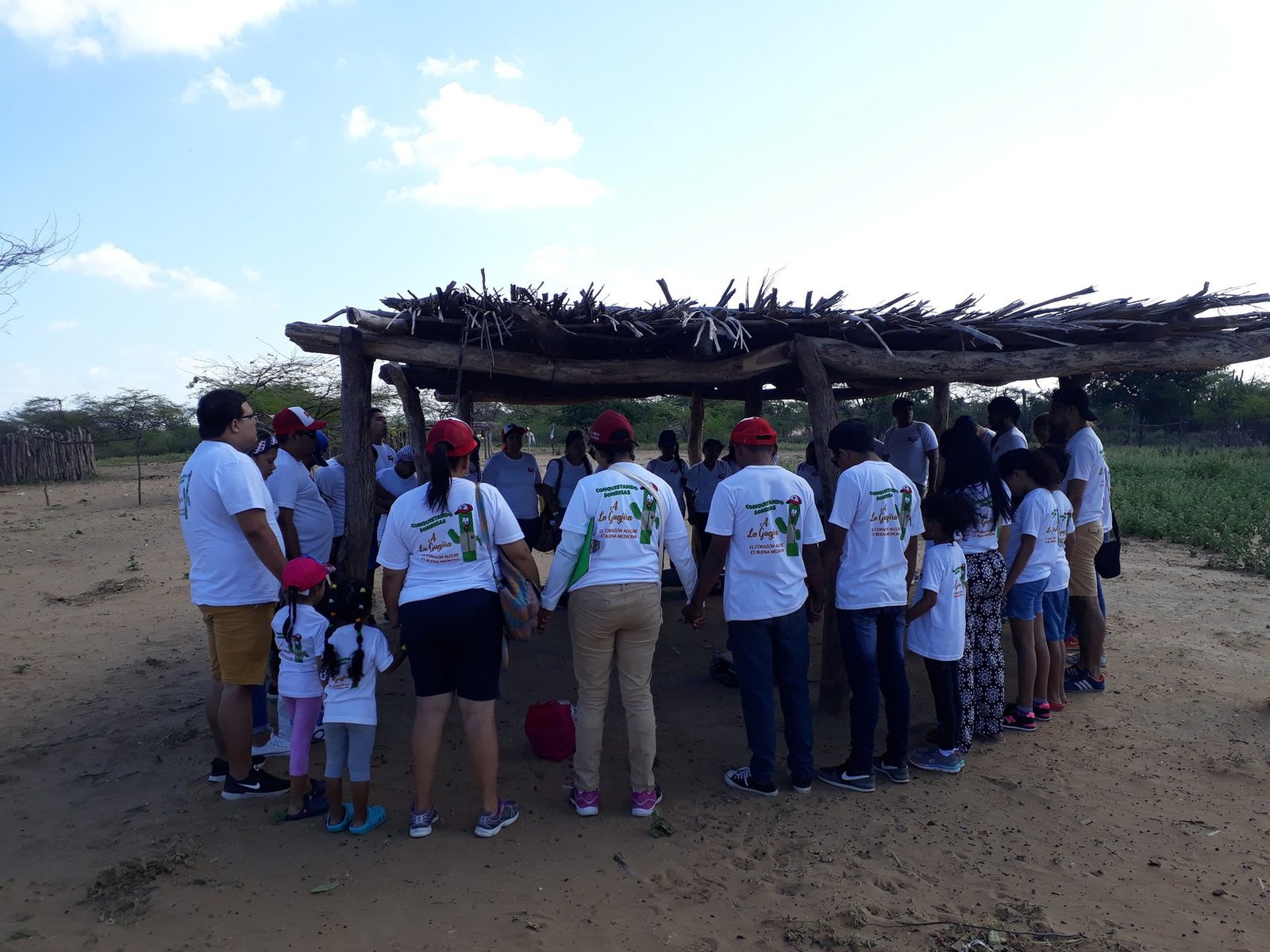 Equipo de voluntarios de la fundación reunido en oración en una ranchería de La Guajira