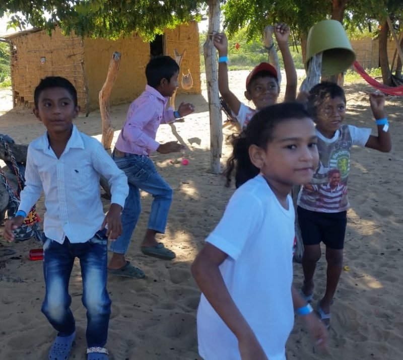 Niños y niñas jugando en la ranchería durante una jornada comunitaria