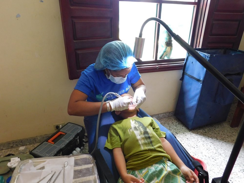 Odontóloga atendiendo a un niño en una jornada de salud oral